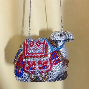Macro view of crystal camel evening bag with intricate rhinestone patterns and silver chain