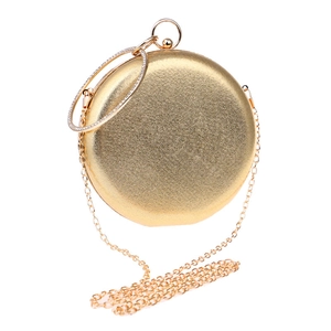 Détail du sac de soirée rond doré avec poignée anneau en strass et chaîne en métal