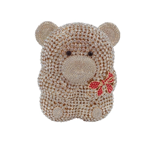 Gros plan du sac de soirée ours en peluche avec cristaux brillants et nœud rouge