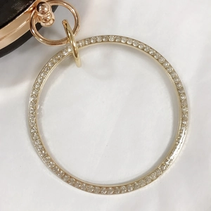 Détail de la poignée en métal doré ornée de strass brillants pour pochette de soirée