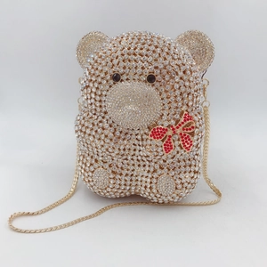 Détail de la pochette ourson sertie de strass cristallins et d'un nœud rouge