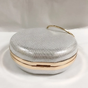 Détail du sac de soirée pailleté argenté avec cadre doré et poignée anneau chic