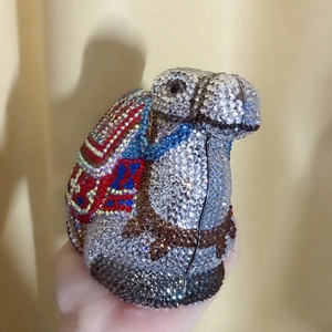 Detailed view of handmade camel-shaped clutch bag with multicolor crystal embellishments