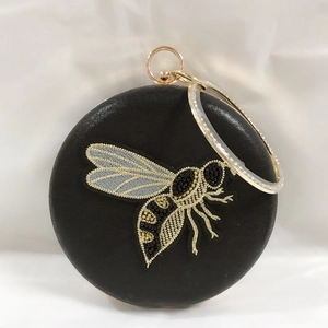 Detailed embroidery of gold and silver beaded bee on a black velvet evening clutch bag