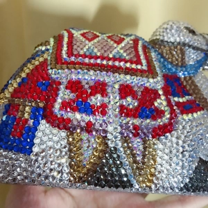 Macro shot of colorful handcrafted crystal beads and geometric rhinestones on camel bag
