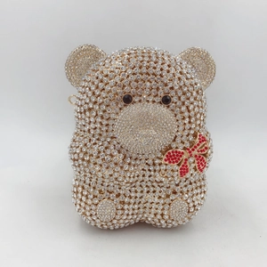 Détails d'une pochette de soirée ours avec strass en cristal et nœud papillon rouge
