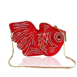 Détail macro de la pochette poisson rouge en strass avec texture et chaîne dorée