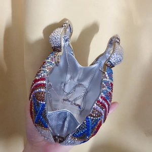 Detail of owl crystal evening bag interior with silver lining and metal shoulder chain