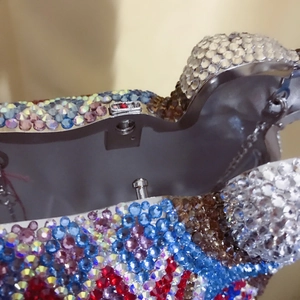 Close-up of multicolored crystal rhinestones and silver metal clasp on camel evening bag