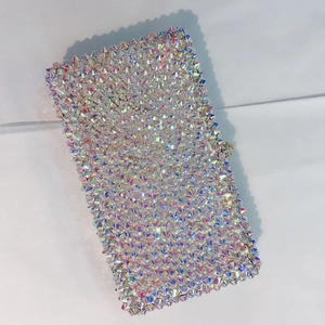Detailed view of square evening clutch bag with iridescent colorful crystals and metal clasp