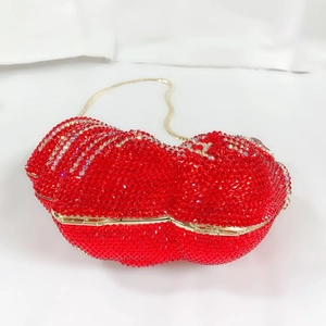 Détail d'une pochette de soirée en forme de lèvres rouges avec strass et chaîne en métal doré
