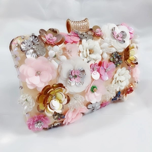 Detailed close-up of handmade sequin flowers and crystal clasp on luxury satin evening bag