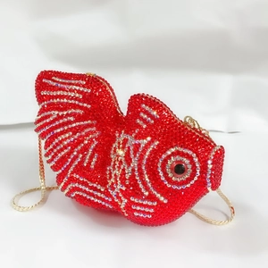 Détail d'une pochette poisson rouge en strass avec écailles et chaîne dorée