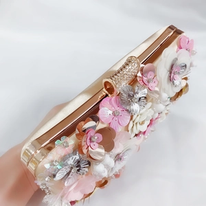 Close-up of luxury evening bag with 3D sequin flowers and diamond-encrusted clasp