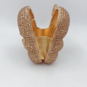 Vue détaillée de la pochette papillon ouverte ornée de cristaux dorés et doublure
