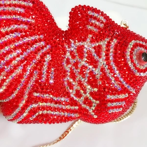 Macro de strass rouges et argentés sur une pochette de soirée en forme de poisson
