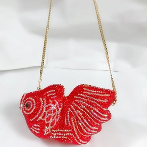 Gros plan de la pochette poisson rouge sertie de strass avec chaîne dorée