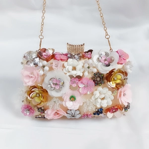 Detail of handmade champagne satin evening bag with 3D beaded flower sequins and diamond clasp