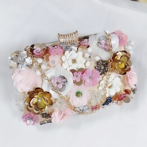 Close-up of champagne clutch bag with 3D fabric flowers, sequins and diamond clasp