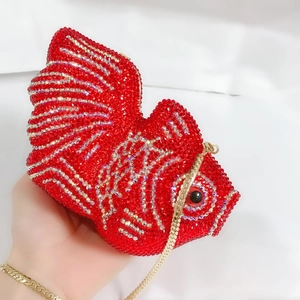 Vue détaillée du sac pochette poisson rouge orné de cristaux avec sa chaîne dorée