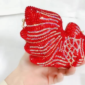 Gros plan du sac de soirée poisson rouge avec motifs en cristal et fermoir métallique