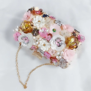 Detail of evening clutch with 3D floral sequins, bead embroidery and golden chain strap