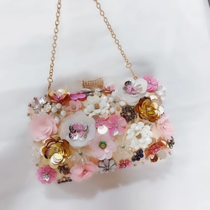 Detail of 3D floral sequins and pearl embroidery on satin evening clutch with rhinestones