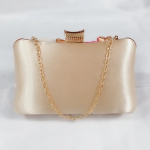 Elegant champagne satin evening clutch bag with gold chain strap and crystal clasp for weddings