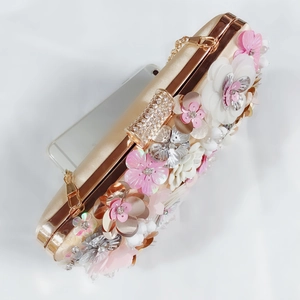 Detail of champagne satin evening bag with 3D floral beadwork and rhinestone clasp