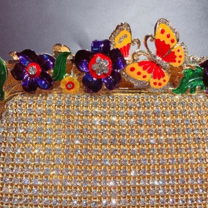 Pochette de soirée dorée luxueuse avec strass étincelants et accents de fleurs et papillon