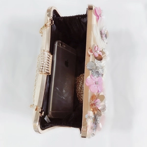 Detail view of champagne satin evening bag interior with phone showing capacity