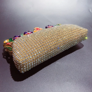 Vue détaillée d'une pochette de soirée dorée avec strass et décors floraux émaillés