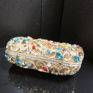 Détail de la pochette de soirée luxueuse avec vigne dorée et cristaux multicolores brillants