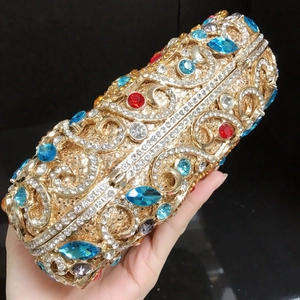 Détail de la pochette paon luxueuse sertie de strass colorés sur monture dorée