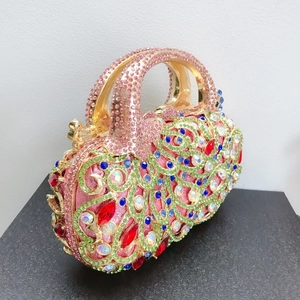 Détails du motif de paon en strass et pierres rouges sur cette pochette de luxe