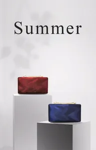 Detail of burgundy and navy PU leather evening clutch bags with wavy texture and gold handles