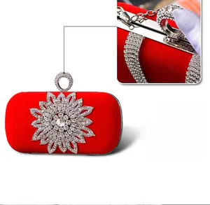 Detail of red velvet evening bag with large floral rhinestones and metallic clasp