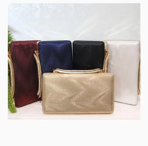 Close-up of evening clutch bags in multiple colors with wavy texture and rhinestone trim