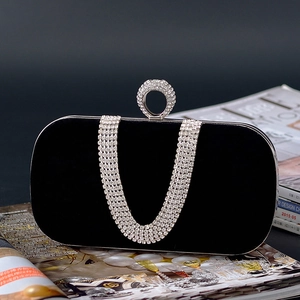 Detail of black velvet clutch bag with U-shape diamond ring clasp and rhinestone chain