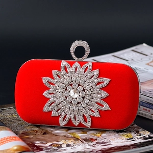 Macro detail of red velvet clutch with crystal flower inlay and rhinestones decoration