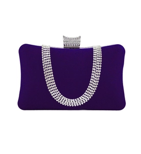 Close-up of purple velvet evening clutch with sparkling rhinestone chains and metal clasp