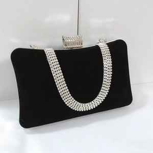 Detail of black velvet evening bag with sparkling U-shaped diamond clasp and rhinestone chain