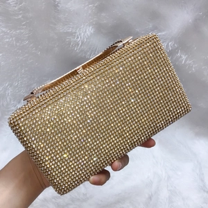 Dettaglio della pochette da sera con strass oro champagne e chiusura a scatto
