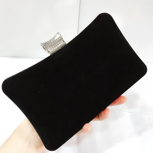 Detail of elegant black velvet evening clutch featuring a sparkling rhinestone metal clasp