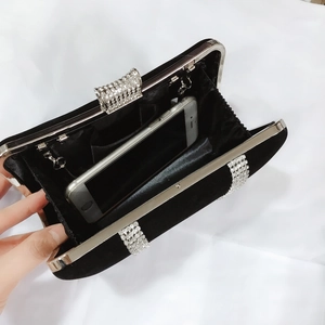 Detail view of the black velvet evening clutch interior with rhinestone trim and storage