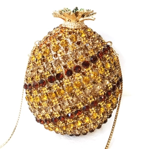 Detail of pineapple crystal clutch with yellow pavé rhinestones and gold leaf top
