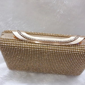 Dettaglio ravvicinato di una lussuosa pochette da sera dorata con strass e chiusura