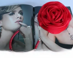 Detail of red satin rose petal layers and golden clasp on an evening formal handbag