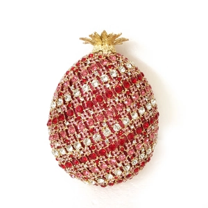 Detailed view of colorful rhinestones and gold leaf closure on pineapple clutch bag