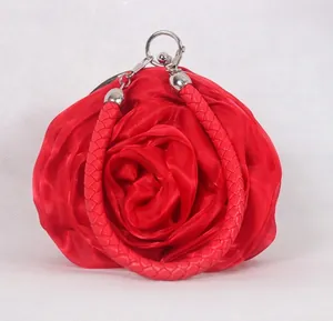 Detailed view of the red satin rose petal layers and woven wristlet of the evening bag